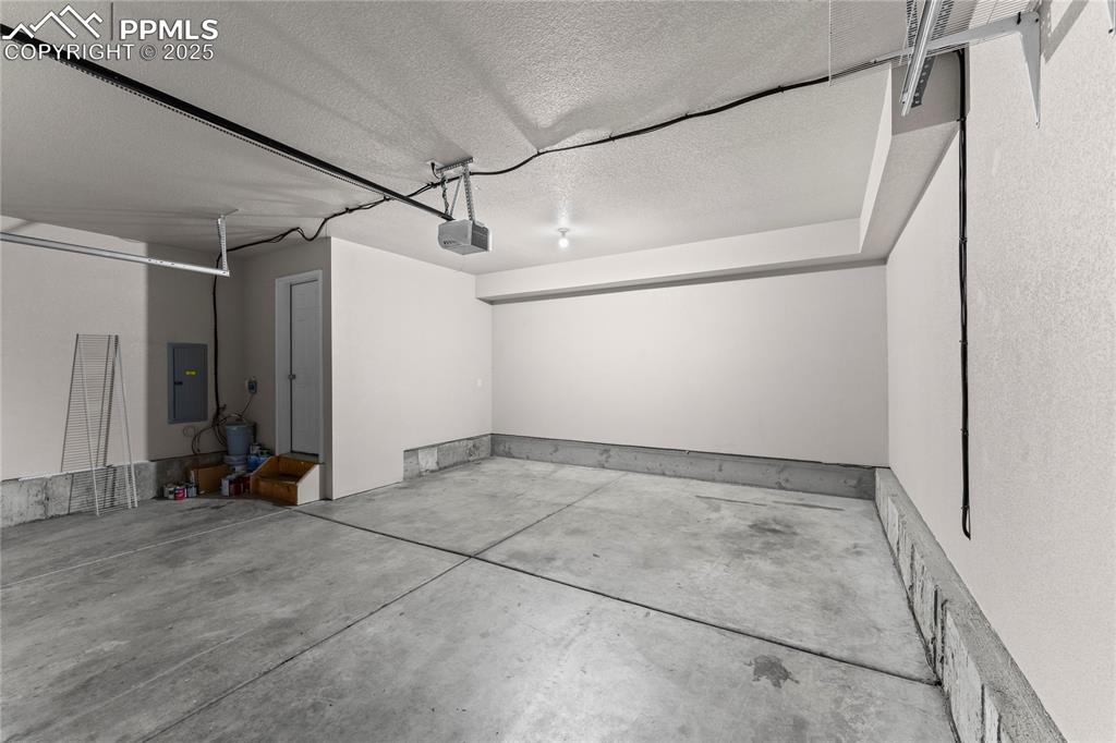 Garage with electric panel and a garage door opener