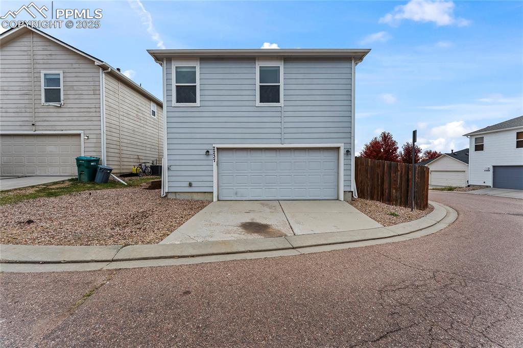 View of front facade featuring driveway and an attached garage