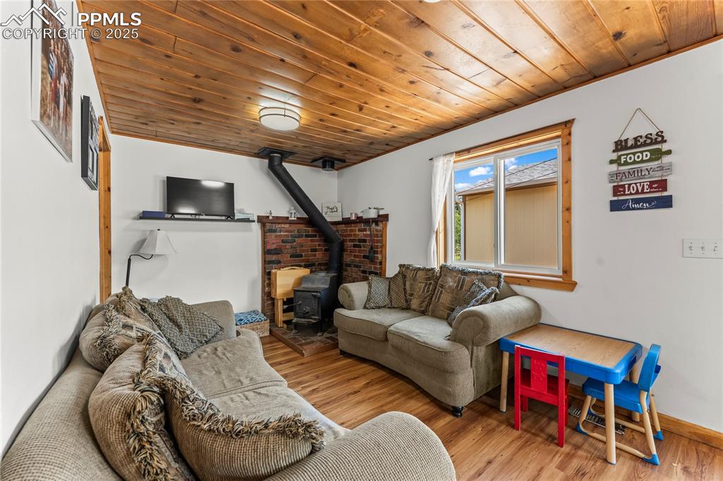 Living area with a wood stove, wood ceiling, and wood finished floors