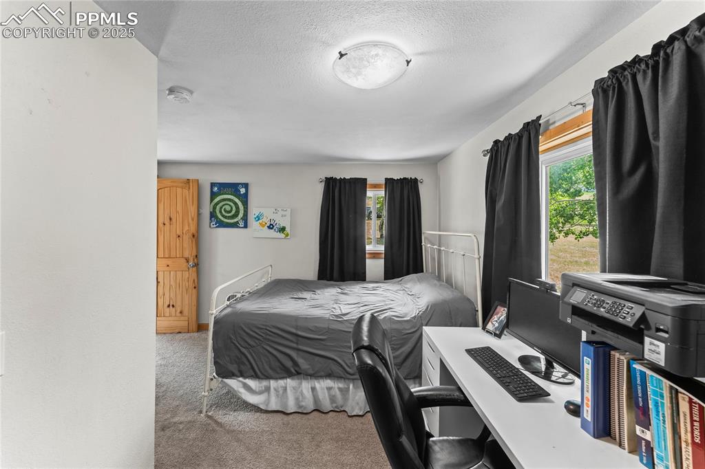 Bedroom with light carpet and a textured ceiling