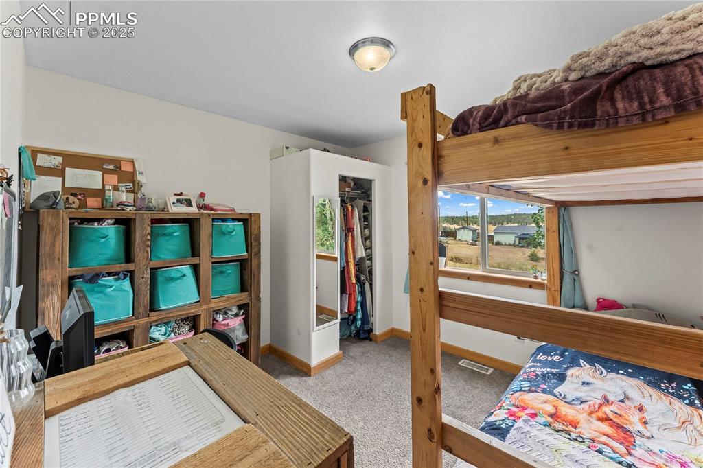 Carpeted bedroom featuring baseboards and a closet