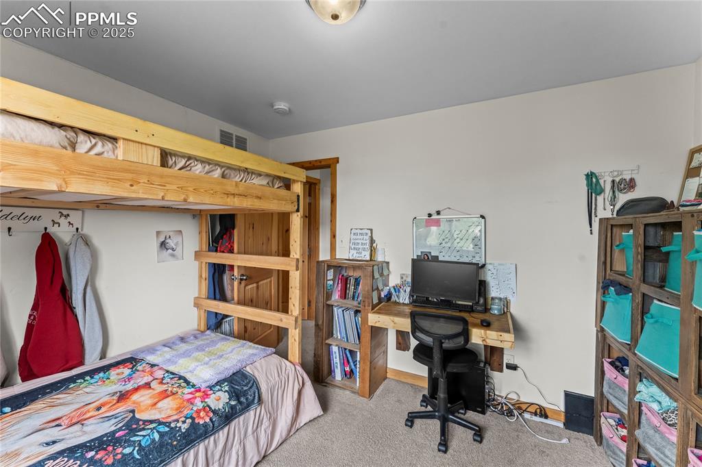 Bedroom featuring carpet floors and a desk