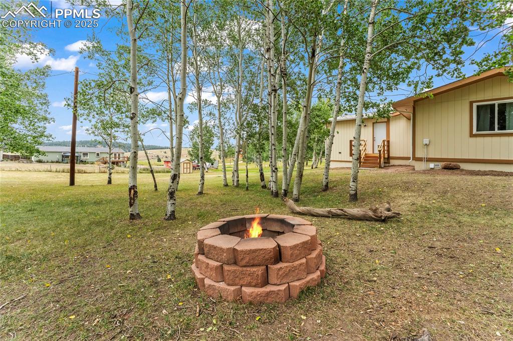 View of grassy yard with a fire pit