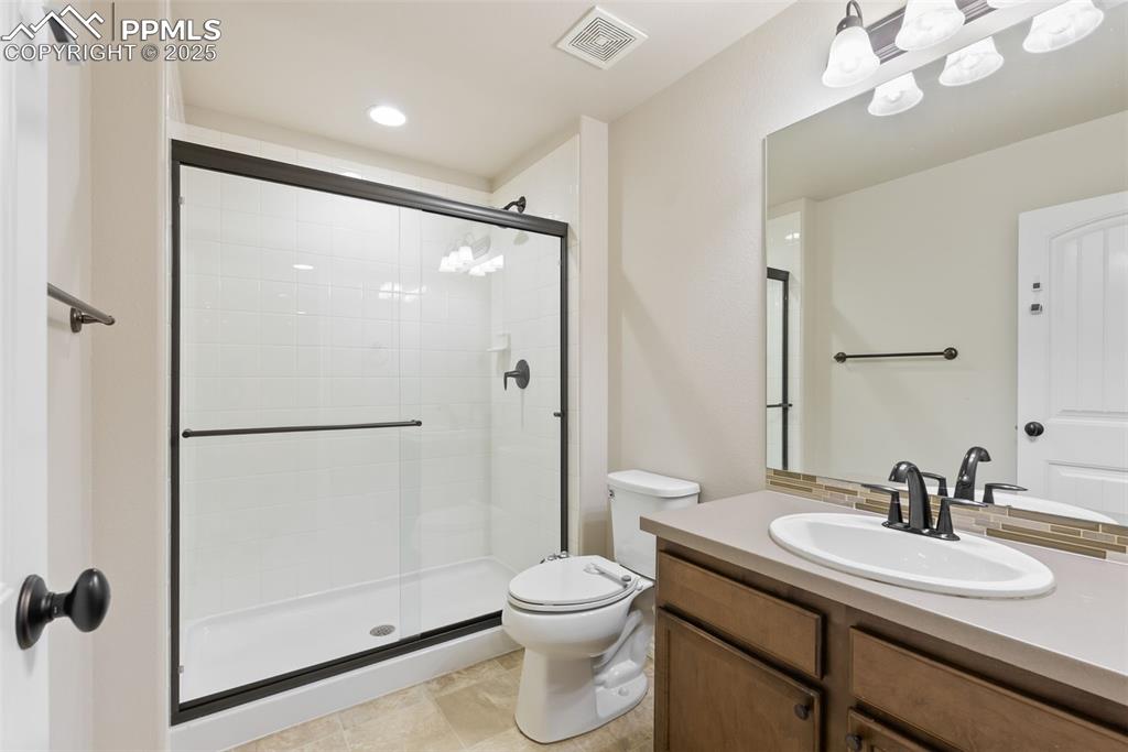 Full bathroom featuring vanity, a stall shower, and recessed lighting