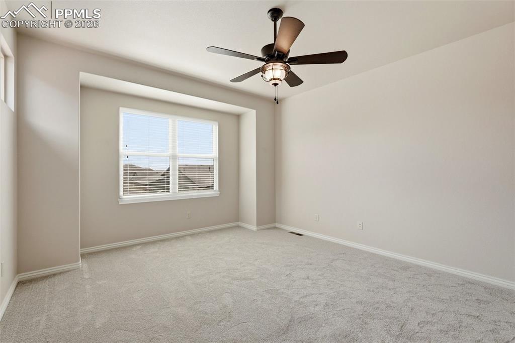 Unfurnished room featuring light carpet and a ceiling fan