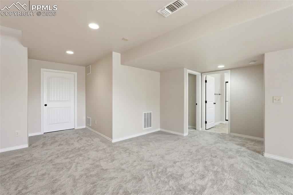 Empty room featuring recessed lighting and light colored carpet
