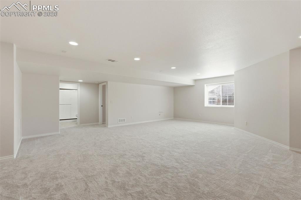 Empty room with recessed lighting and light carpet
