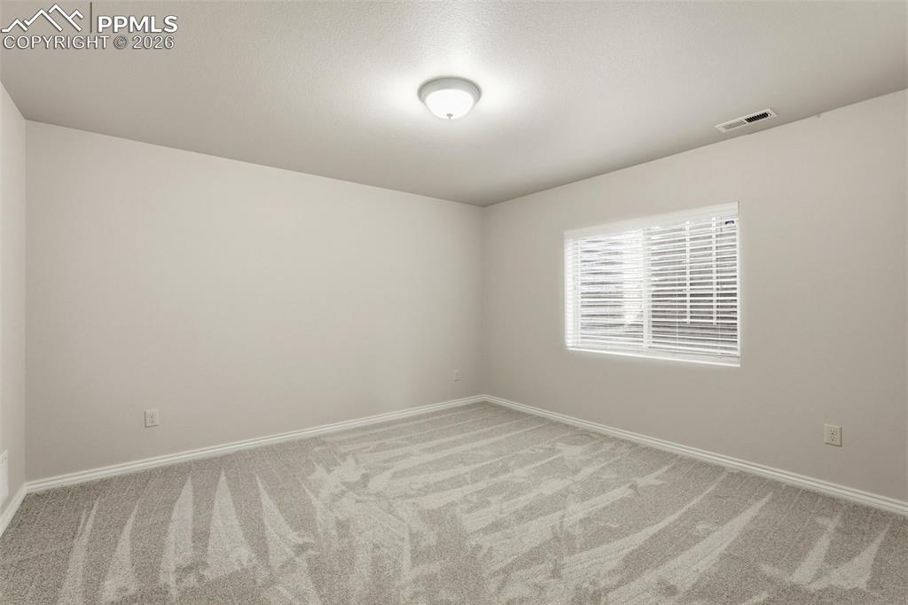 Empty room with baseboards and light carpet