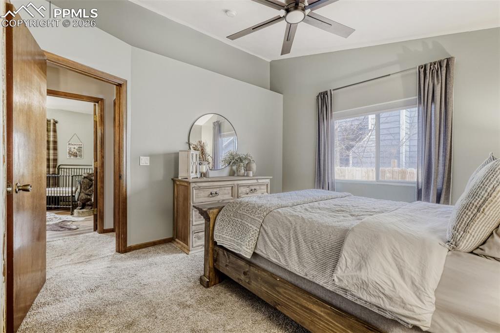 Carpeted bedroom featuring ceiling fan and baseboards