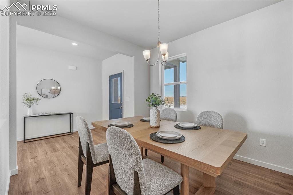 Dining room with a chandelier, wood finished floors, and recessed lighting