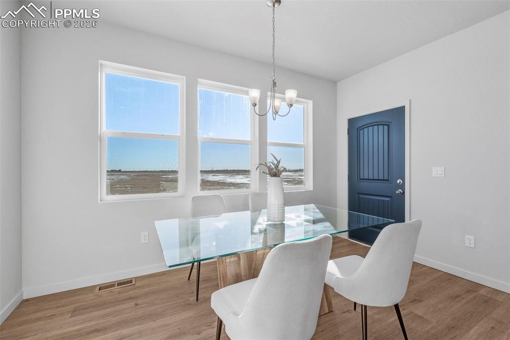 Dining area with light wood-type flooring and a chandelier