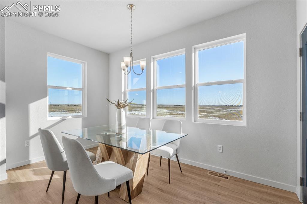 Dining space with light wood-type flooring and a chandelier