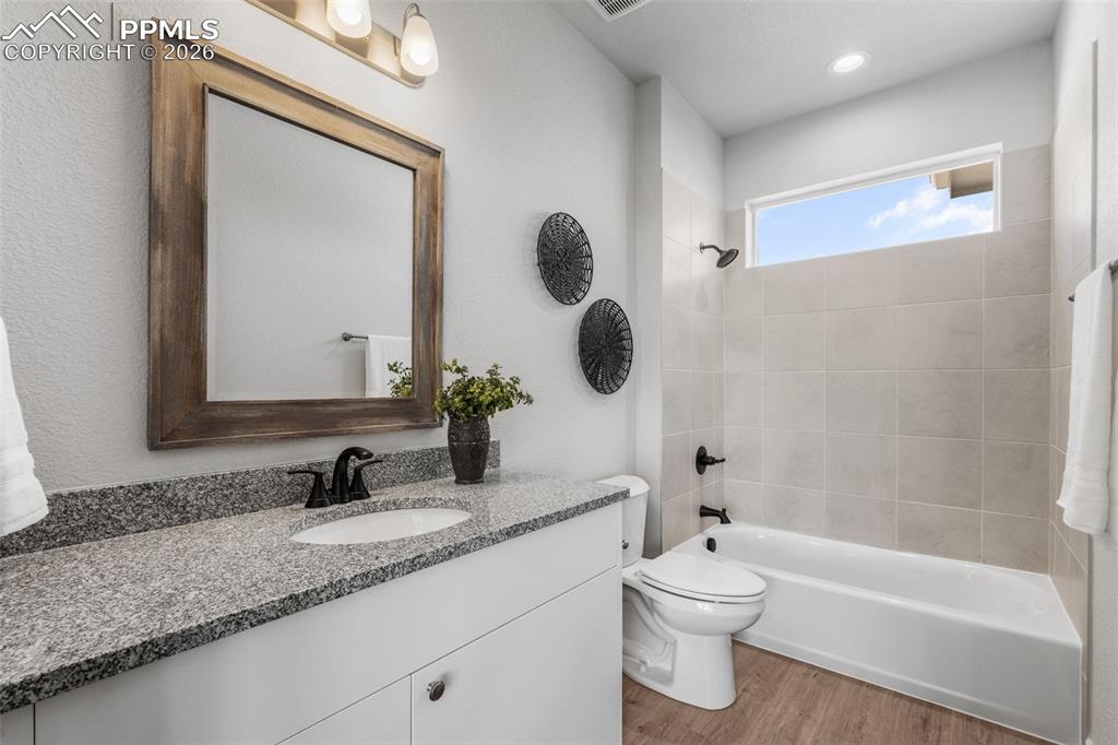 Bathroom with vanity, tub / shower combination, and light wood-type flooring