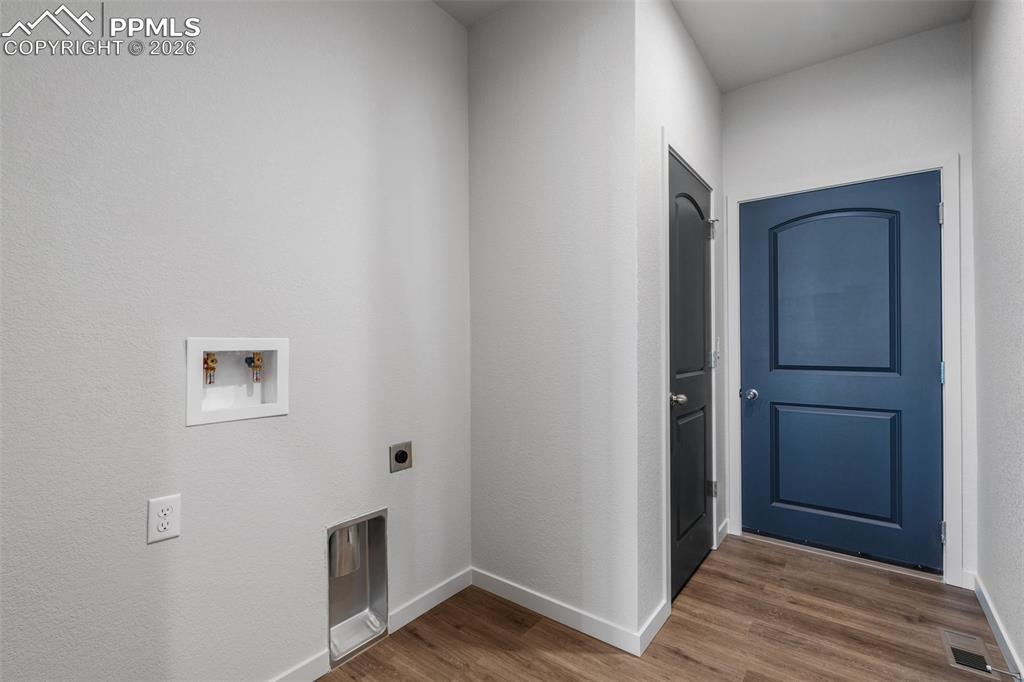 Laundry area featuring dark wood finished floors, washer hookup, and hookup for an electric dryer