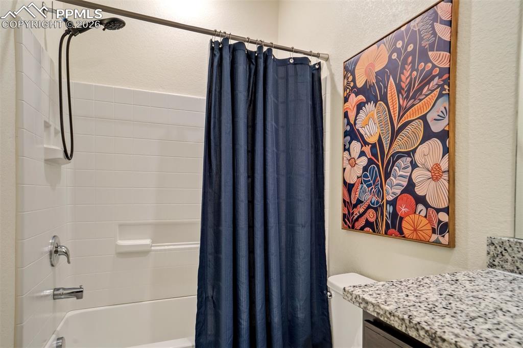 Shower/ tub and granite countertops. 