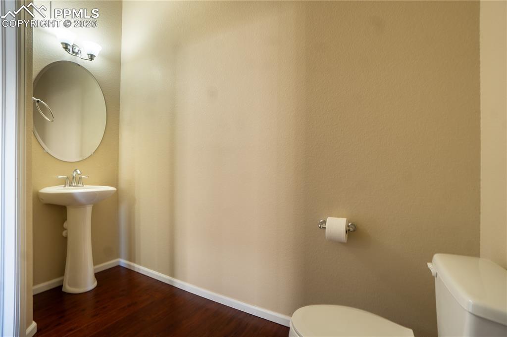 Bathroom with toilet and dark wood-style flooring