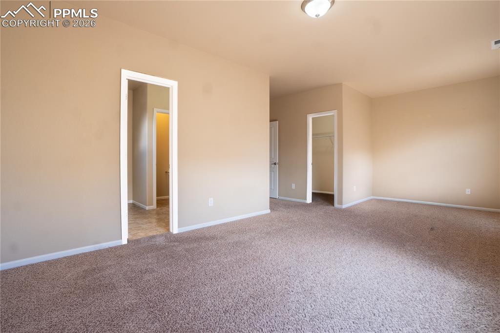 Unfurnished bedroom with a spacious closet and carpet floors