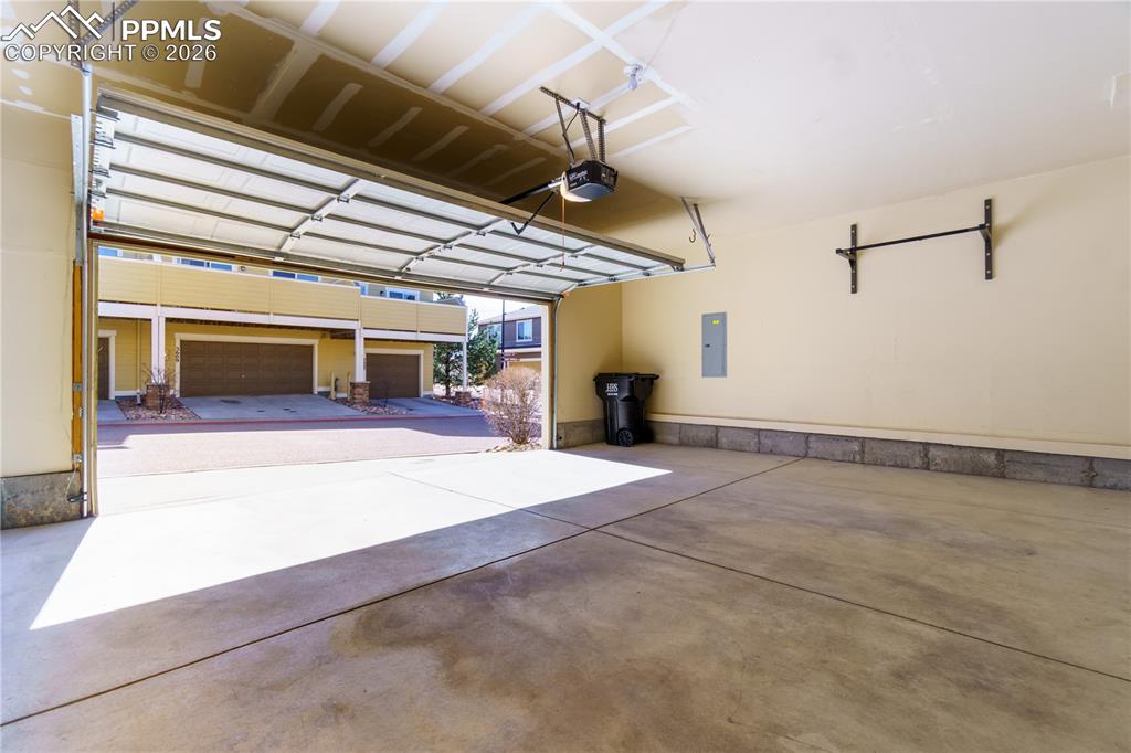Garage featuring electric panel and a garage door opener