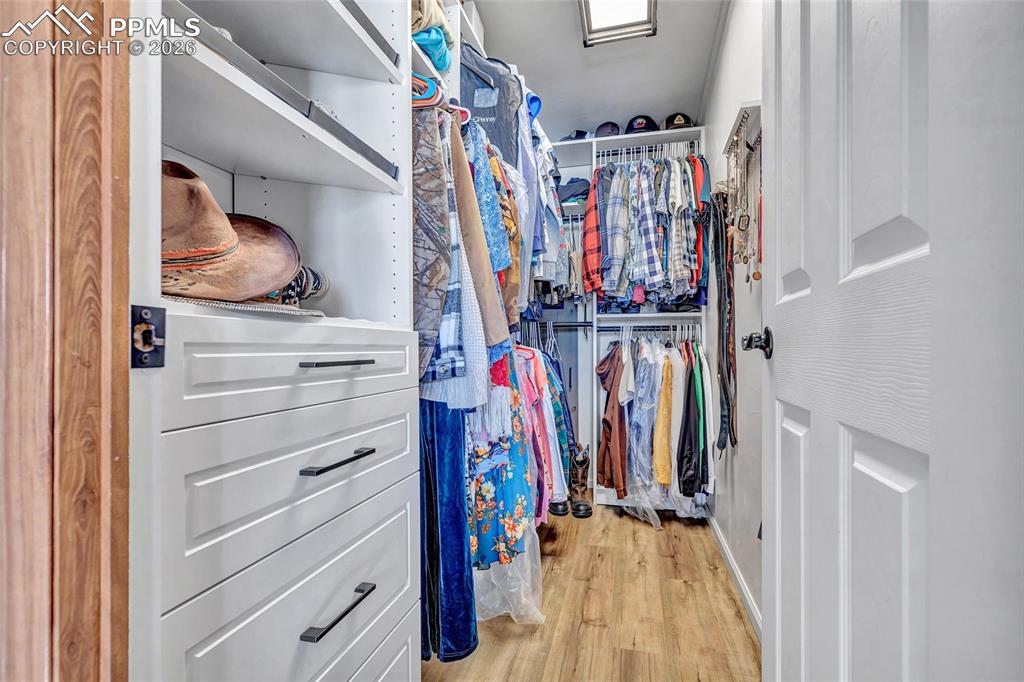 Walk in closet with light wood-style floors