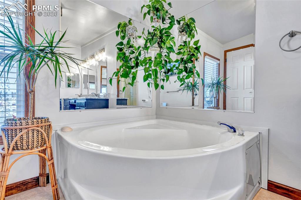 Bathroom featuring a bath and baseboards
