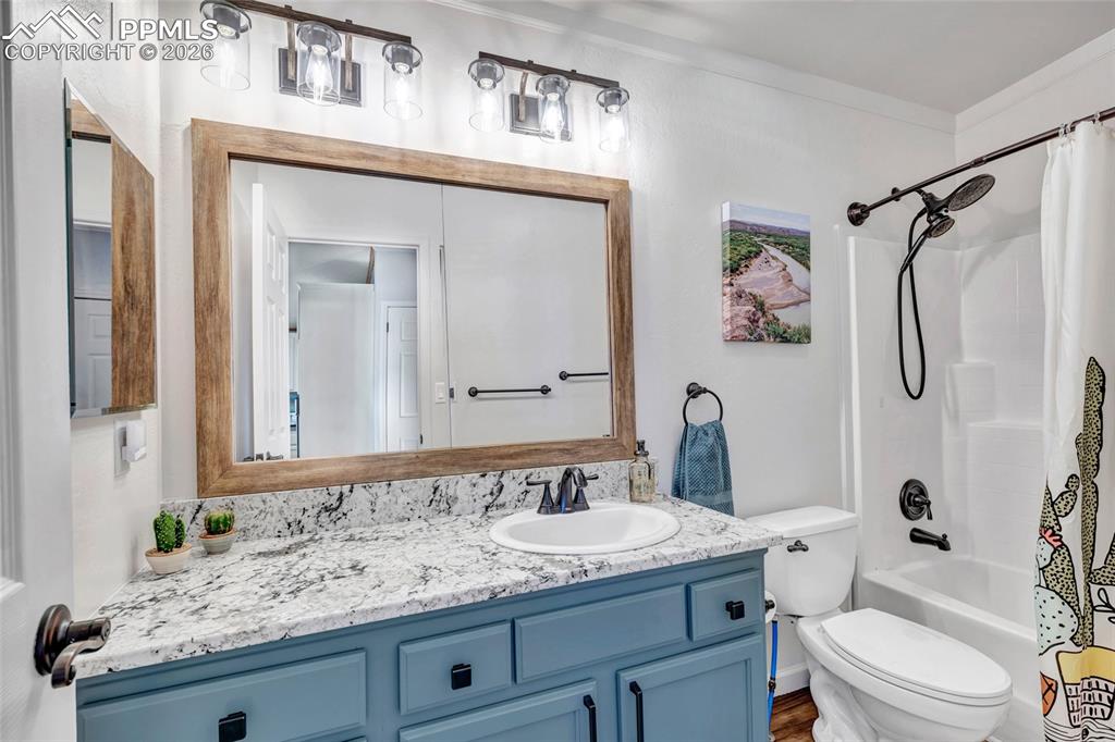 Full bath featuring vanity and shower / bath combo with shower curtain