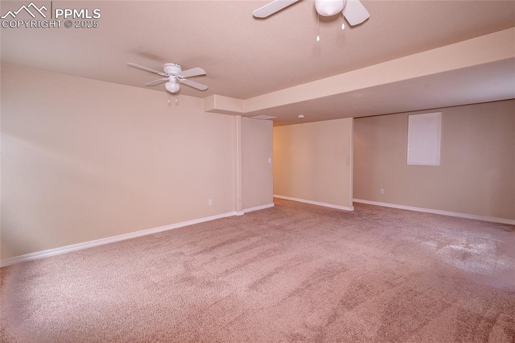 Spare room featuring a ceiling fan and light colored carpet