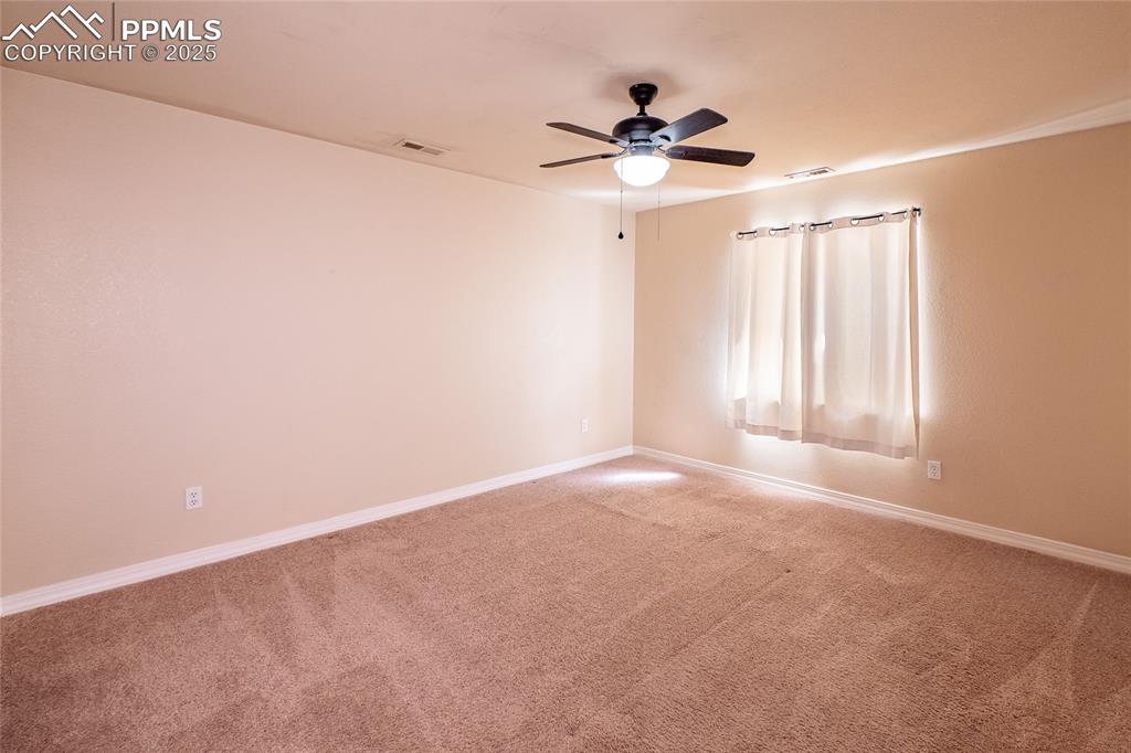 Spare room featuring carpet floors and a ceiling fan