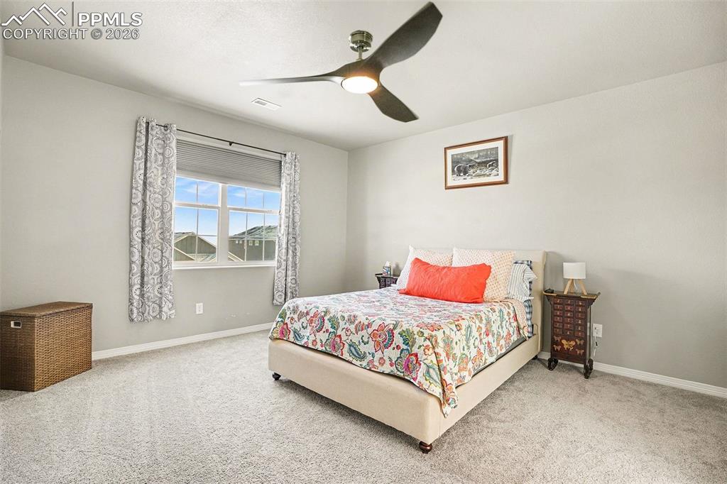 Bedroom with a ceiling fan and carpet flooring