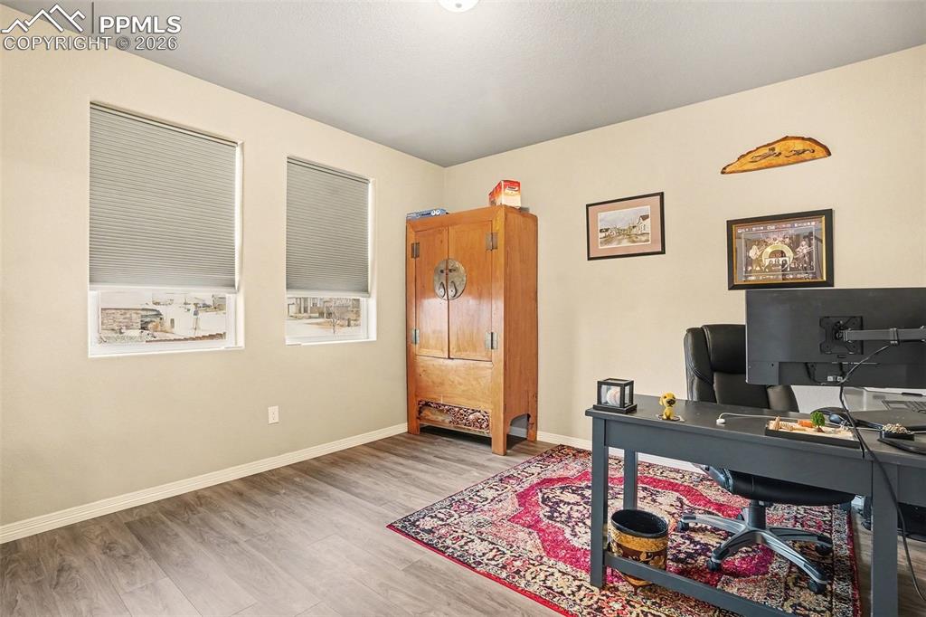 Office with light wood-style flooring and baseboards