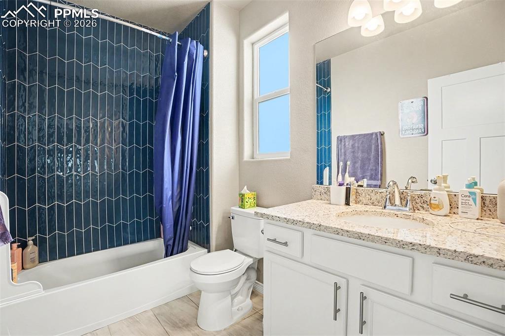 Full bath with shower / bath combo with shower curtain and vanity