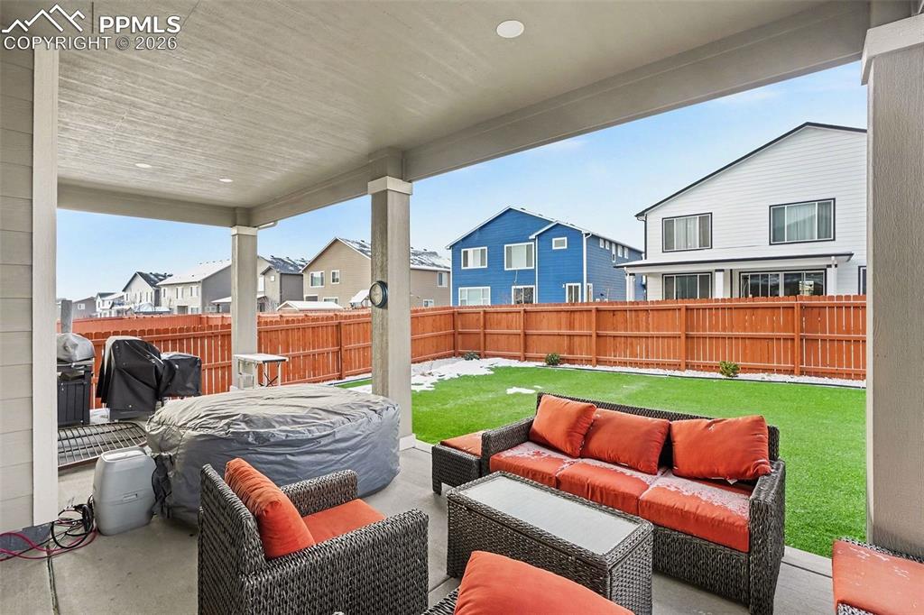 Fenced backyard featuring a patio, a residential view, and an outdoor hangout area
