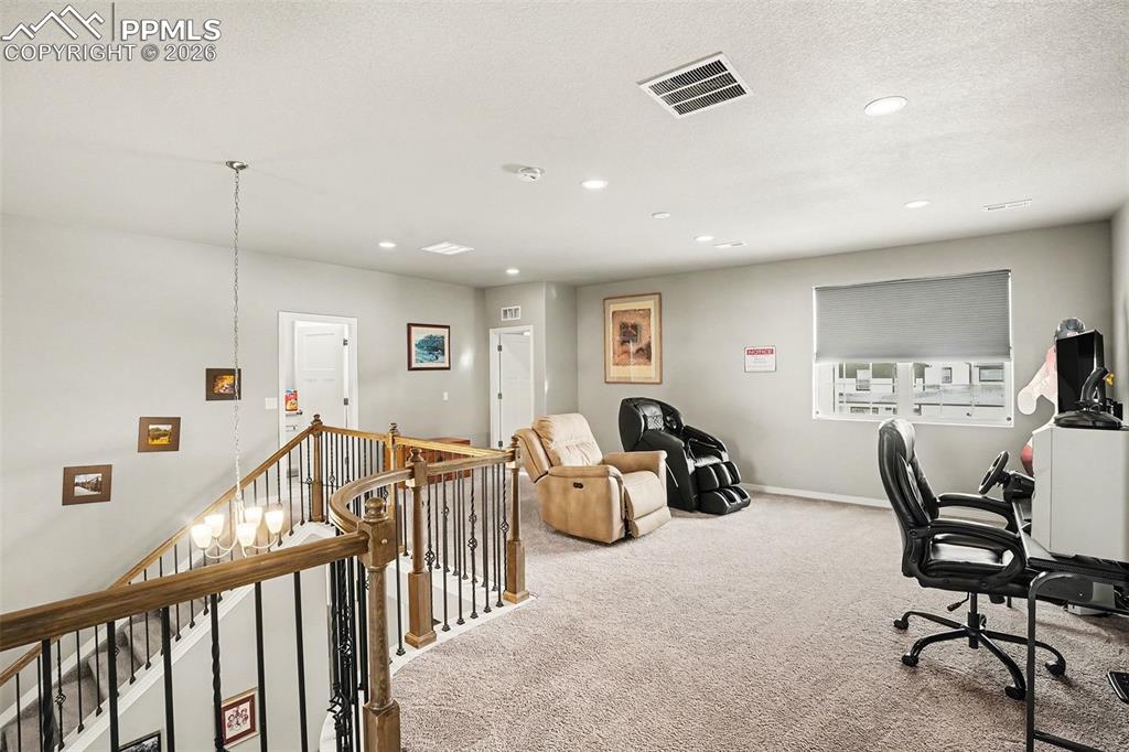 Carpeted office space with a chandelier, recessed lighting, and a textured ceiling