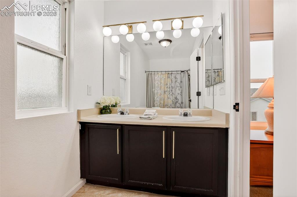 Primary bathroom with double sinks, ceramic tile and tub/shower