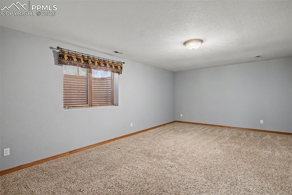 Spare room with light colored carpet and a textured ceiling
