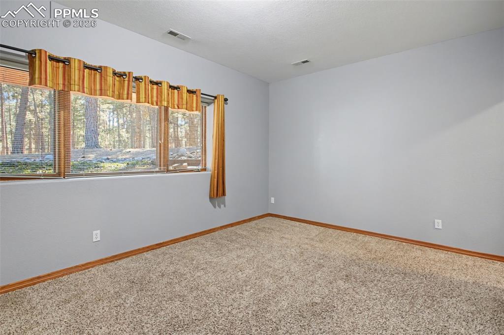Spare room featuring light carpet and baseboards