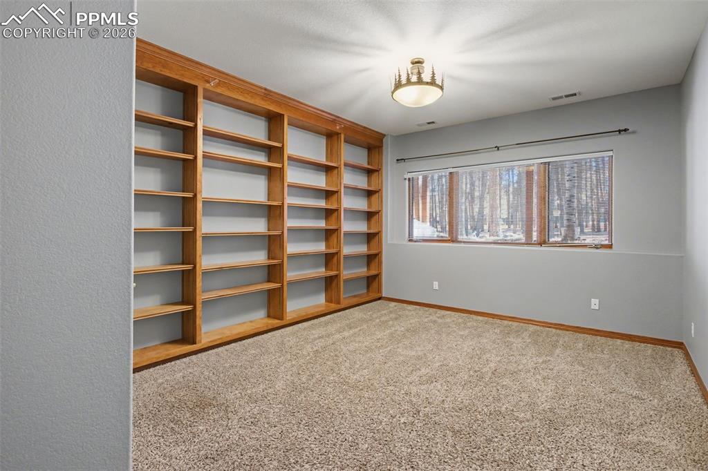 Empty room featuring light carpet and baseboards