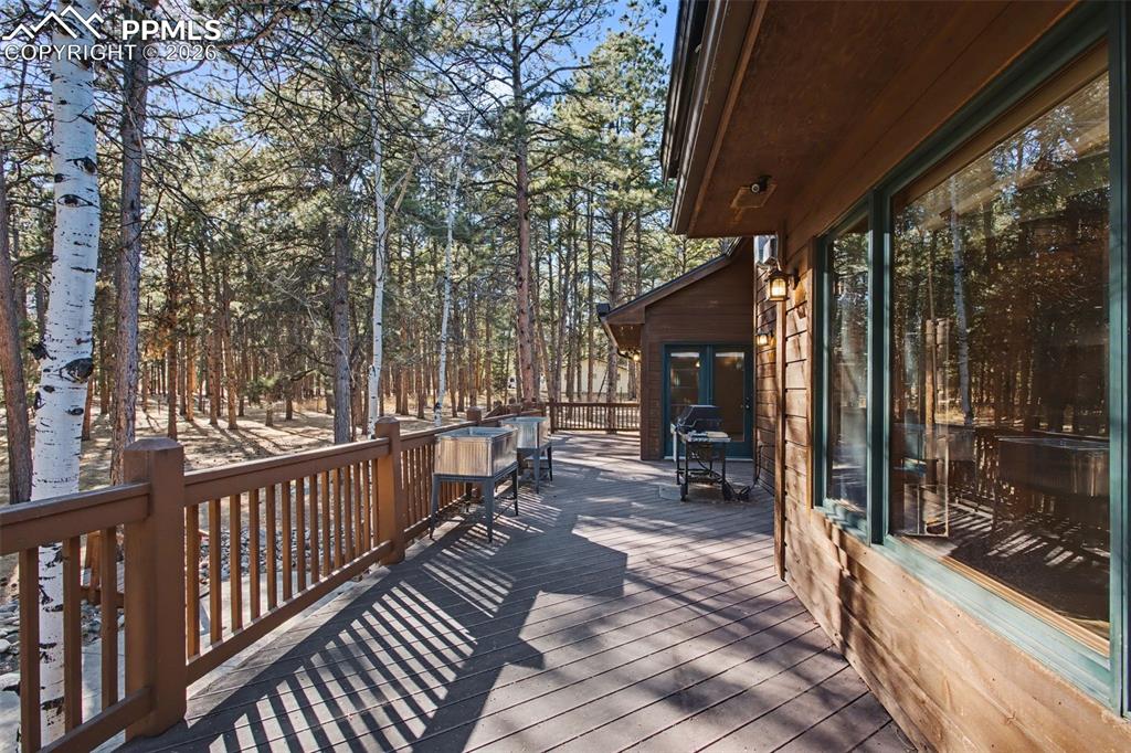 Wooden deck featuring a grill and view of scattered trees