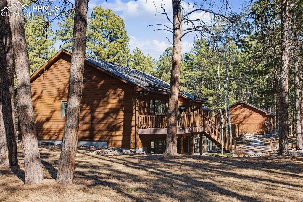 View of property exterior with stairway and a wooden deck