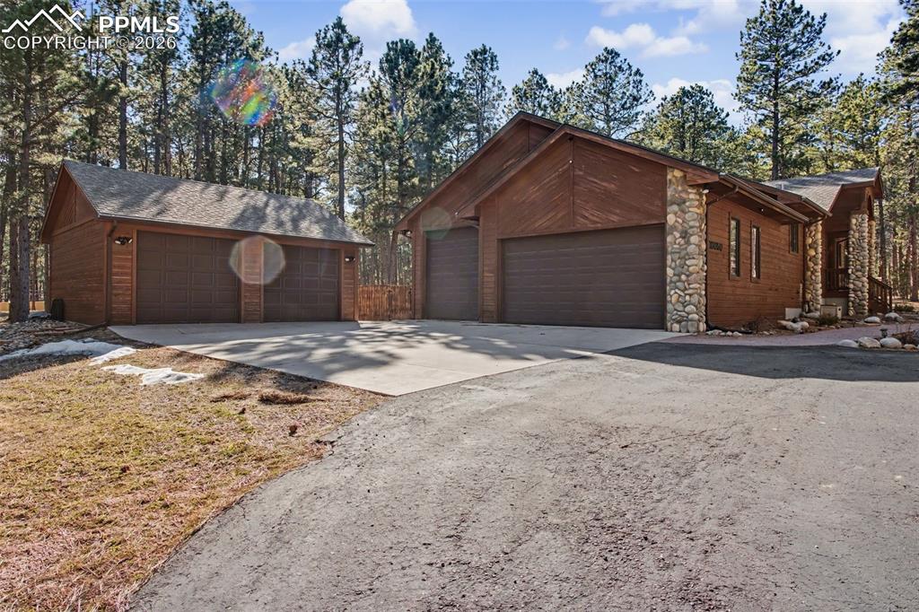 View of front of property featuring stone siding and concrete driveway