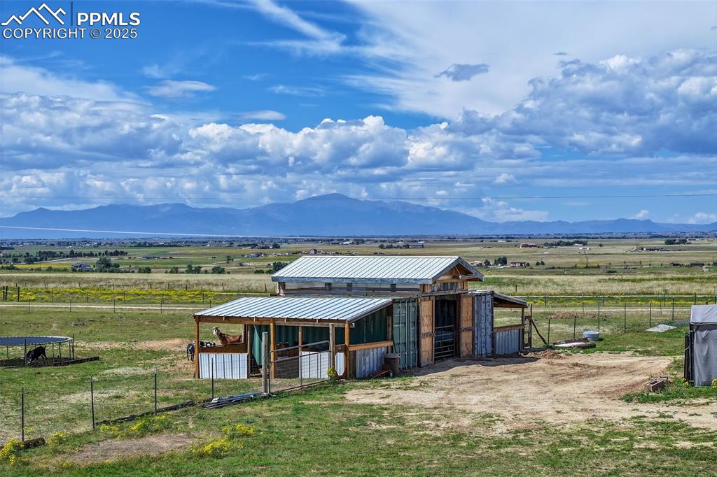 View of outdoor structure with a view of rural / pastoral area, an exterior structure, a mountain view, and agricultural plots