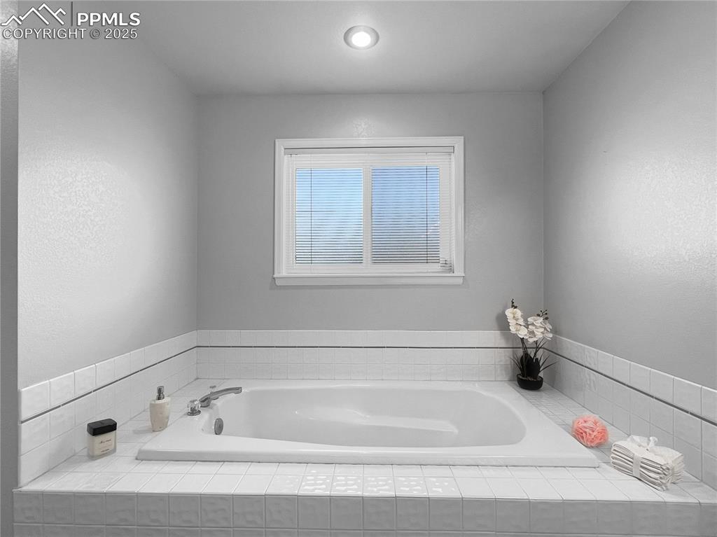 Full bathroom with a bath and a textured wall