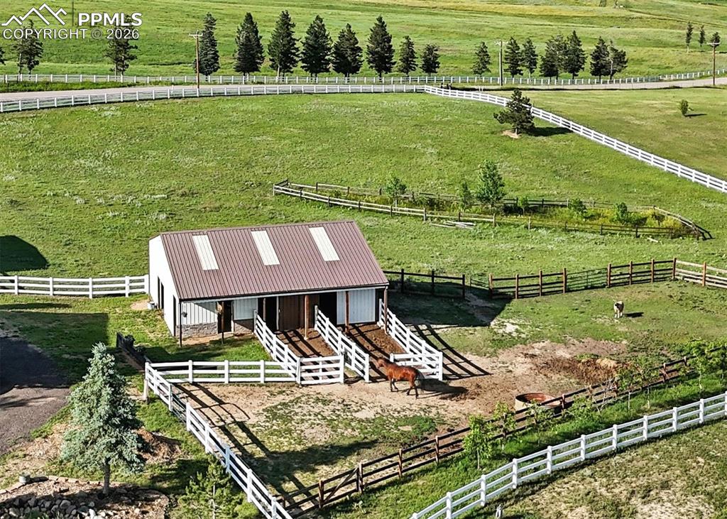 30x40 barn is fully equipped with two Priefert horse stalls, water and electric, a tack room, workshop, horse paddocks, and fenced pastures.