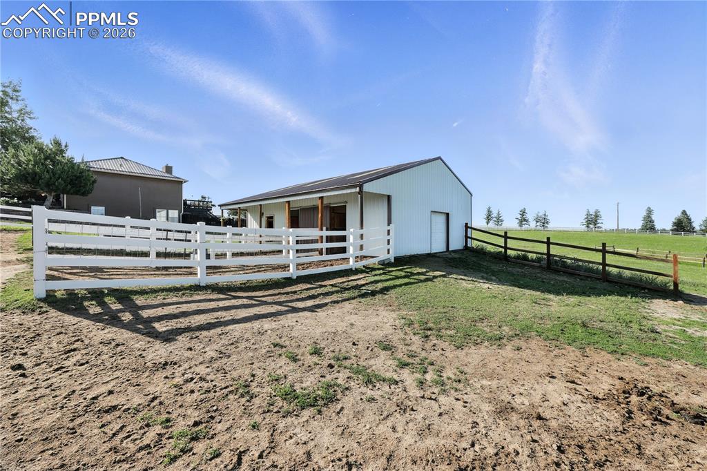 30x40 barn is fully equipped with two Priefert horse stalls, water and electric, a tack room, workshop, horse paddocks, and fenced pastures.
