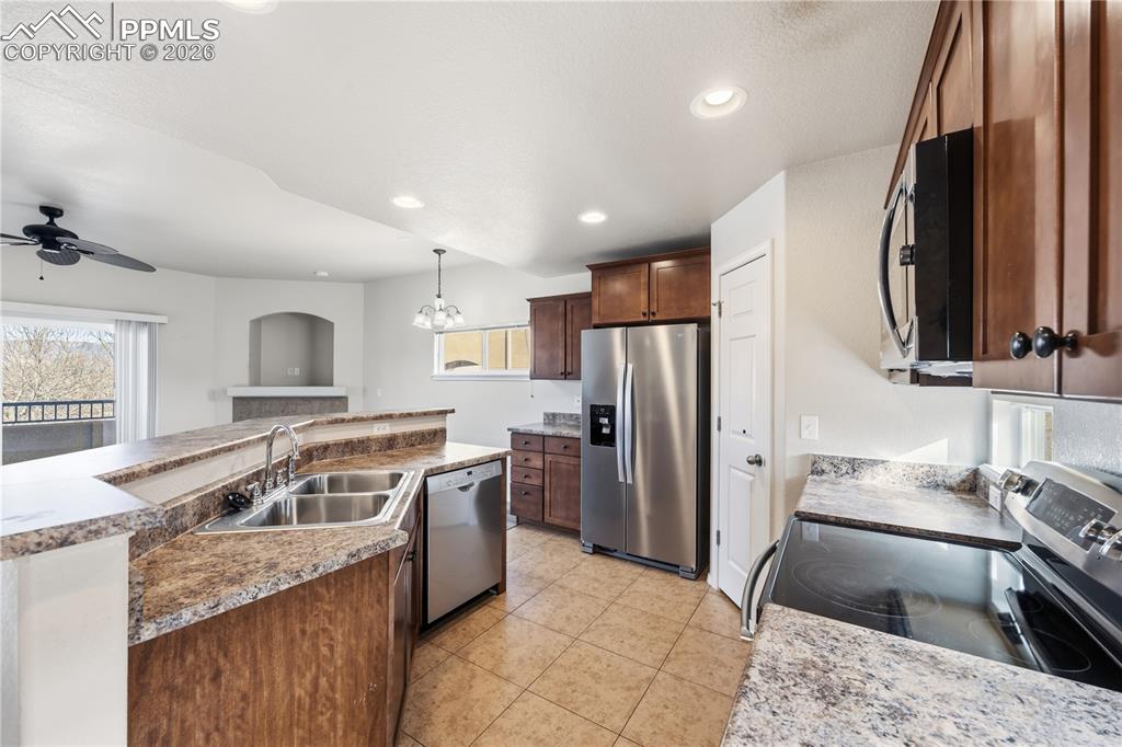 Stainless steel appliances include a double sink, dishwasher, side by side refrigerator, smooth top oven, and builtin microwave oven.