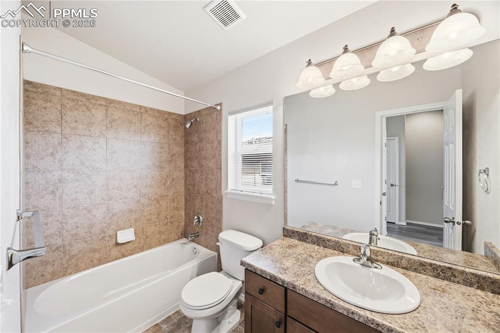Full Hall Bathroom with vanity, mirror, and tiled tub/shower