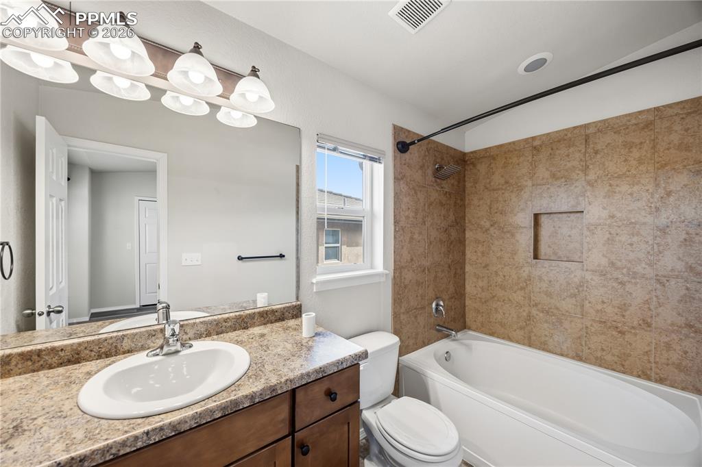 The Primary Bathroom offers a vanity, mirror, and tub/shower.