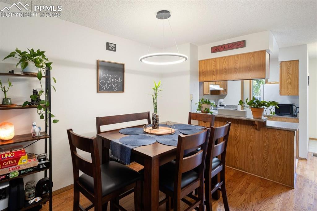 Dining space with light wood-style flooring and a textured ceiling