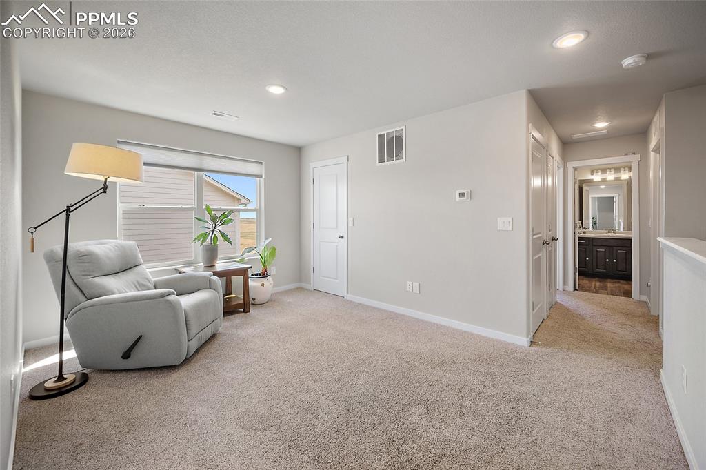 Loft flex space with view to third bedroom entry, full guest bath, and laundry room