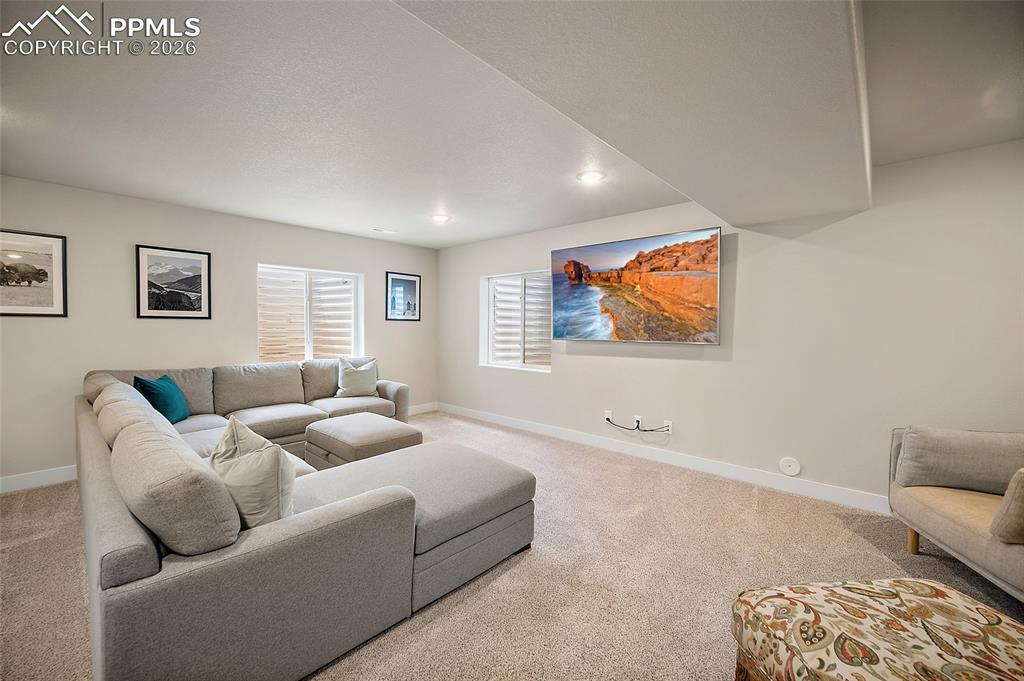 Basement theater room complete with 76" wall mounted flatscreen with concealed wiring