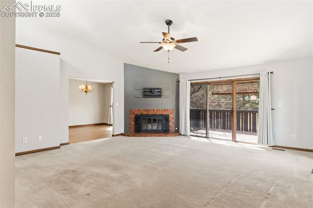 Vaulted living room with a fireplace and walk out to the deck